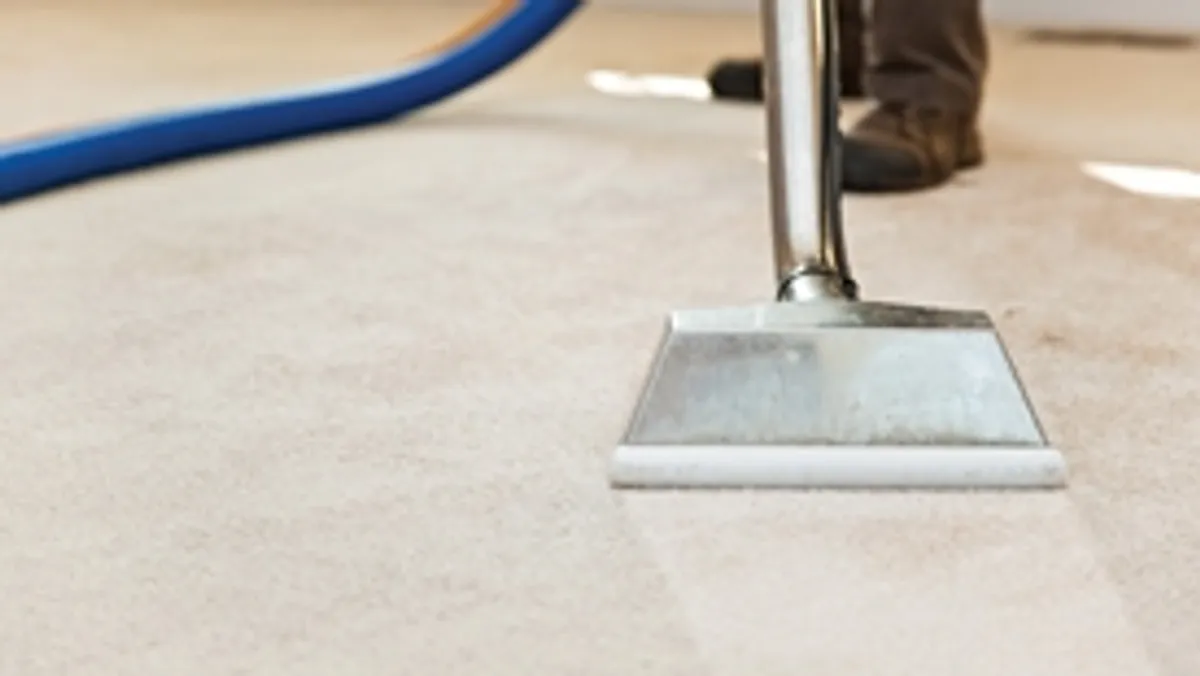 Carpet cleaning wand head gliding over a light carpet during hot-water extraction, Boca Raton, FL.